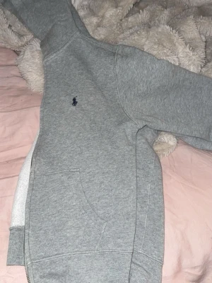 Grå hoodie från Polo Ralph Lauren - Säljer min lillasysters hoodie, jätte fint skick förutom att det är ett litet hål på armen. Kom gärna med prisförslag 