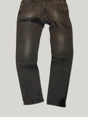 Svarta replay jeans med snygga fades - Säljer ett par svarta jeans med slim fit passform och diskreta slitningar framtill. Klassisk femficksmodell med normal midja och snygga sömmar på bakfickorna. Perfekta till en avslappnad streetstil. Materialet är denim i bomull.