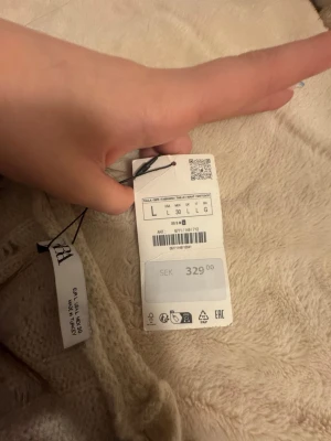 Beige stickattröja från Zara - Mysig beige stickattröja  från Zara med fluffig och mjuk textur. Tröjan har en enkel design och är perfekt för att hålla värmen under kyliga dagar. Passar dig som gillar en avslappnad och trendig stil.