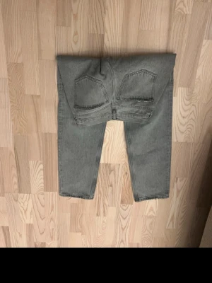 Grå raka jeans från Weekday - Säljer ett par grå jeans från Weekday med rak passform och klassisk femficksdesign. Jeansen har normal midja och är tillverkade i ett slitstarkt denimtyg. Perfekta för en avslappnad och trendig look.