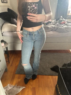 Ljusblå utsvängda jeans - Säljer ett par snygga utsvängda jeans med hål vid knät. Aldrig använd men ingen lapp kvar då jag tog av den direkt efter köp❤️