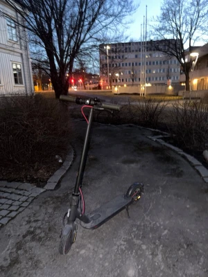 Svart elscooter med röda detaljer - Säljer en svart elscooter med röda detaljer på kablarna. Scootern har en robust ram i metall, bred fotplatta med halkskydd och handtag i gummi. Utrustad med skivbroms bak och stöd. Perfekt för att ta sig fram snabbt i stan.