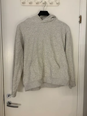 Ljusgrå basic hoodie med huva - Hoddie med luva från H&M. Snörena som ska vara i den har jag dragit ur. Den har en ficka på magen.