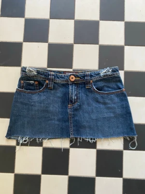 Lågmidjad jeanskjol  - Säljer denna lågmidjade jeanskjolen från denim co med midjemåttet 36,5cm och som är 26,5cm lång 