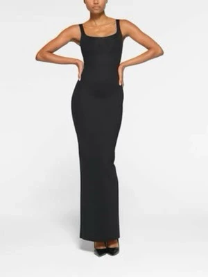 Svart långklänning med slits SKIMS body tank long slip dress S - Stilren svart långklänning med smala axelband och figurnära passform. Klänningen har en klassisk rundad urringning och en diskret slits baktill för extra rörelsefrihet. Perfekt för dig som gillar minimalistisk och tidlös stil.