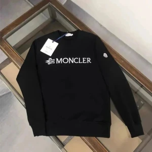 Svart Moncler sweatshirt - Svart sweatshirt från Moncler med stor vit logga framtill och klassiskt Moncler-märke på ärmen. Tröjan har rund halsringning och långa ärmar med ribbade muddar. Perfekt för en clean och stilren look.