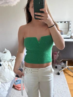 Grön stickad tubtopp - Snygg grön stickad tubtopp med croppad passform och en unik v-ringad detalj framtill! 