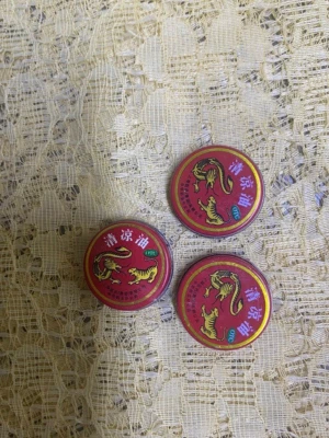 Tre burkar kinesisk tigerbalsam - Säljer tre små runda burkar med klassisk kinesisk tigerbalsam. Burkarna är röda med guldiga kanter och har motiv av en tiger samt kinesiska tecken på locket. Perfekt för dig som gillar traditionella skönhetsprodukter.