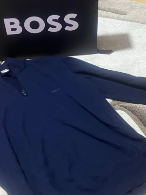 Boss stickad tröja halv zip – mycket bra skick -  Säljer en stilren stickad  Boss tröja med halv zip i storlek S. Tröjan är i mycket bra skick och endast använd ett par gånger. Köptes för cirka 1200 kr. Originalförpackning ingår.  En klassisk och bekväm tröja av hög kvalitet – passar både till vardag och mer uppklädda tillfällen.  Pris: 800 kr.