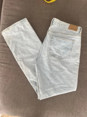 Ljusblå raka jeans från Gina Tricot - Säljer ett par ljusblå jeans Gina Tricot med klassisk femficksdesign och raka ben. Jeansen har en snygg vintagekänsla och är tillverkade i denim med en ljus tvätt. Perfekta till en avslappnad och trendig stil. Finns någon knappt synlig fläck längst ner. Mid waist storlek 38. Köpta på vinted men tyvärr för stora för mig! 