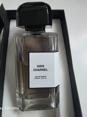 Gris Charnel Eau de Parfum 100ml - Gris Charnel från BDK Parfums är en exklusiv Eau de Parfum på 100 ml. Flaskan är elegant och genomskinlig med en svart, glansig fyrkantig kork och minimalistisk vit etikett. Doften är känd för sin unika och moderna karaktär, perfekt för dig som gillar stilrena och lyxiga parfymer.