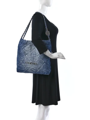 Blå quiltad handväska  - Säljer en snygg blå quiltad handväska med kedjeaxelband och tydlig logotyp framtill. Väskan har en mjuk denimlook och kommer med original dustbag och autenticitetskort. Perfekt för dig som vill ha en lyxig och trendig accessoar.