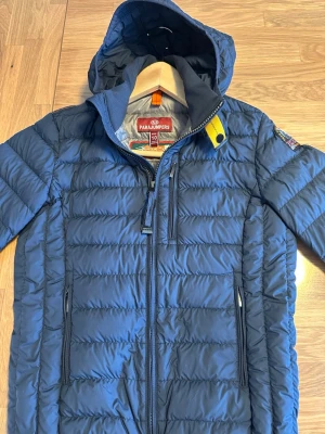 Parajumpers Barn Super lightweight dunjacka - I mycket fint skick (använd men väl omhändertagen). Ett litet hål som jag har lämnat in hos skräddare och lagat (se bild 5). Köpt på NK i Stockholm. Storlek 10 (barn/youth). Pris kan diskuteras vid snabb affär.