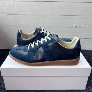 Maison Margiela (GATS) - Otroligt fina Mörkblåa Maison Margiela Skor i Otroligt Bra skick! Storleken 43 men passar även 42. Tveka inte att höra av dig vid funderingar! (Äkhetsbevis finns inkl Box och dustbags)