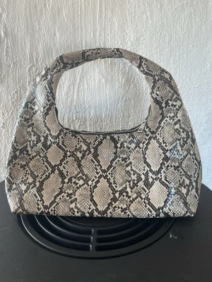 Handväska från Gina Tricot - Snygg handväska i läderimitation från Gina. Aldrig använd.