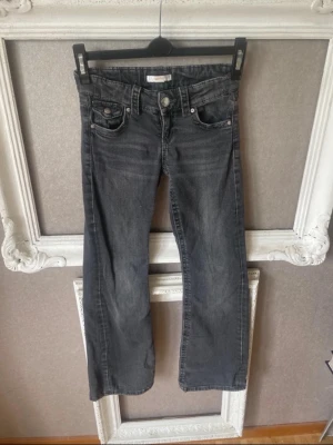 Grå bootcut jeans med fickor - Säljer ett par grå bootcut jeans med snygga bak fickor. Jeansen har låg midja. 
