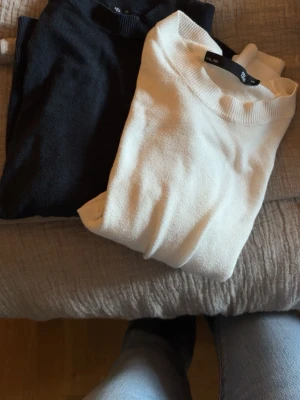 Svart och vit croppad topp  - Två stilrena croppade toppar i svart och vitt. Båda har rund halsringning och korta ärmar. Perfekta att matcha med jeans eller kjol för en enkel och snygg look. Materialet känns mjukt och stretchigt, troligen bomull eller bomullsblandning. Man kan välja att köpa båda eller en styck.