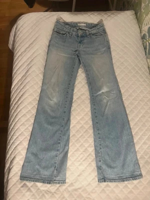 Ljusblåa bootcut jeans  - Säljer dessa ljusblåa low waist bootcut jeansen ifrån Gina tricot i storlek 32💗Jättesnygg passform med knappfickor där bak! Eftersom de har varit uppsydda sen innan har de som streck längst ner på vardera ben, samt en liten svag fläck längst ner på högra ben. Men det är inget som man tänker på 