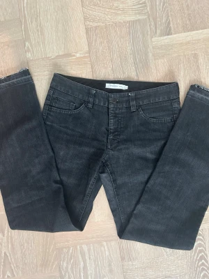 Svarta bootcut jeans från Stockh LM - Snygga svarta jeans från Stockh LM med bootcut passform och klassisk femficksdesign. Jeansen har bälteshällor och en diskret logga på metallringen vid fickan. Tillverkade i denimtyg som ger en avslappnad look.