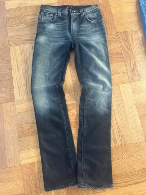 Sällsynta svarta slim bootcut Nudie Jeans - Säljer dessa sjukt sällsynta och snygga svarta slim jim/ slim bootcut jeans från Nudie med snygga slitningar. Väldigt snygg och unik wash och snygg bakficksdesign. Finns i princip ingenstans att köpa längre. Modell: slim jim/slim bootcut. storlek 29/32. Väldigt bra skick, inga defekter. Skriv vid eventuella frågor😁