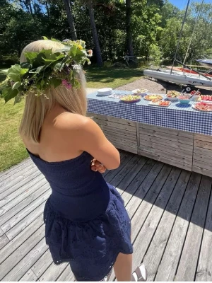 Blå  sommarklänning - Söt marinblå axelbandslös klänning med smock upptill och volangdetaljer nertill. Klänningen har en kort längd och är perfekt för sommarens alla tillfällen. Tillverkad i ett lätt och luftigt material som ger en bekväm passform. Storlek L men omsydd till M/S