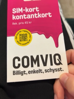 Comviq SIM-kort kontantkort - Säljer ett SIM-kort kontantkort från Comviq. Förpackningen är vit och rosa med svart text och har en QR-kod för registrering. Perfekt för dig som vill ha ett enkelt och schysst mobilabonnemang utan bindningstid.