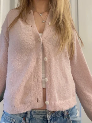 Ljusrosa kofta med knappar - Supernysig kofta ifrån Vera moda perfekt till våren! Aningen norpig. Säljs i befintligt skick se bilderna.