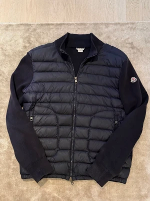 Moncler cardigan - Säljer denna eftertraktade moncler cardigan som kostar nypris 12000kr. Självklart äkta med qr kod och nfc Scan på märket som man kan se på bilderna. Storlek Large och skicket är bra ut över en söm som syts om under märket se bild 7. Inget som syns vid användning! Hör av er vid funderingar😁