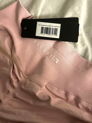 Ljusrosa seamless tights Relode - Helt nya Aura Seamless Scrunch Tights från Relode – storlek M (light pink) 🌸  Säljer dessa helt oanvända tights med lappen kvar. Superfin passform som framhäver kroppen på ett riktigt snyggt sätt tack vare scrunch-detaljen baktill.  Den ljusrosa färgen är verkligen drömmig och perfekt både till löpning och all typ av träning – eller bara för en snygg athleisure-look.  • Storlek: M • Skick: Ny med tags • Modell: Aura Seamless Scrunch • Färg: Light pink  Bekväma, stretchiga och sitter som en dröm!