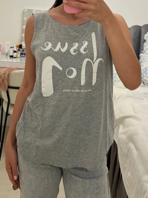 Grått loungewear-set från Jacquline de Yong - Mysigt grått loungewear-set från Jacquline de Yong med ärmlös topp och matchande byxor. Toppen har tryck med texten 'Issue No1' i vitt framtill. Perfekt för chill dagar hemma. Mjukt och stretchigt material för extra komfort.