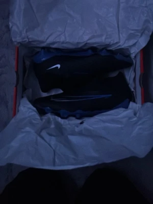 Svarta Nike sneakers med vit swoosh - Snygga svarta sneakers från Nike med vit swoosh på sidan. Skorna har en sportig design och är tillverkade i textil och syntetmaterial. Perfekta för dig som gillar streetwear och vill ha en clean look.