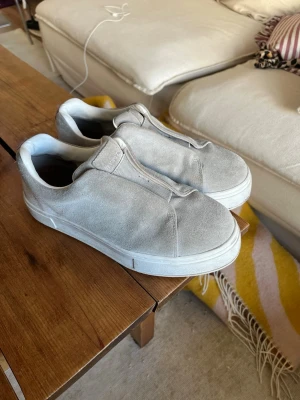 Eytys doja  - Eytys doja sneakers. Originallåda medföljer! De har blivit lite smutsiga i använding, men endast använda förra hösten. Stilrena grå slip-on sneakers i mocka med vit tjock sula. Skorna har minimalistisk design utan snörning och elastiska paneler för enkel påtagning. Perfekta för en clean och avslappnad look.
