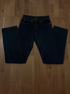 Mörkblå raka jeans - Snygga mörkblå jeans med rak passform och klassisk femficksdesign. Jeansen har normal midja och är tillverkade i ett robust denimtyg. Perfekta för dig som gillar en tidlös och enkel stil.