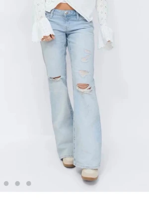 Ljusblå bootcut jeans med slitningar - Säljer men kan också byta till storlek S. Använd två gånger 