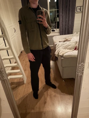 Grön overshirt från Stone Island - Original pris 3600 kr!  Snygg olivgrön overshirt från Stone Island med klassisk patch på ärmen. Overshirten har rak passform, bröstficka och är tillverkad i bomull. 