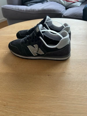  New Balance sneakers - Säljer ett par mörkblåa New Balance sneakers med grå detaljer och klassisk N-logga på sidan. Har använt dom helt okej o är i bra skick skriv  o hör av vid minsta lilla priset kan diskuteras vid snabb affär!