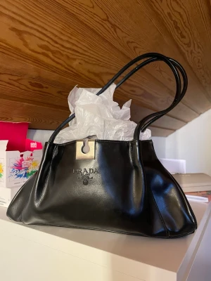 Svart handväska - Vintage handväska ärvd av mamma från många år tillbaka. Fint skick, små skavanker (bilder). Vet ej om ursprung, ingen aning vart den är köpt då den är gammal. 