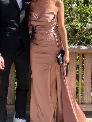Rosa balklänning  - Elegant långklänning i champagnefärgad satin med draperad urringning och hög slits. Köpt på Plick och använd en gång. Jag är 170 och brukar ha S/XS. Skriv privat för fler frågor🍒