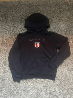 Mörkblå hoodie från GANT - Snygg mörkblå hoodie från GANT i storlek 176cm och säljs för 150kr!