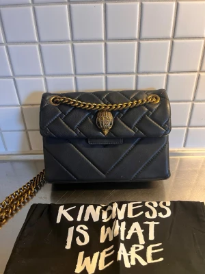 Kurt Geiger väska  - Kurt Geiger väska. - Mini Kensington X bag. Färg: Black comb. Mycket fint skick, lite sliten i kanterna. Se alla bilder. Dustbag medföljer. Kvitto finns. Nypris: 257 EUR 