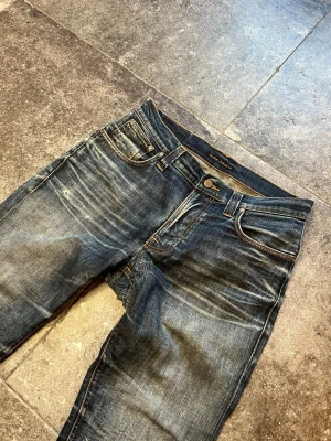 Dry Vintage Nudie Jeans - Slim Fit - oooherregud vart ska jag ens börja, idag säljer jag mina personliga nudie tape teds i 31/32🤧 Med helt störda fades utöver kan jag lätt kalla dessa en av mina fetaste par brallor👏 Skulle säga att dessa sitter lite lösare än ett vanligt par tape teds så tveka inte på att fråga om bild med de på🫡 