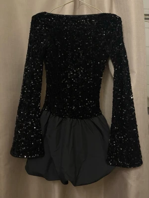 Glittrig festklänning  - Jättefin glittrig miniklänning med öppen rygg, köptes till nyår men kom aldrig till användning så i princip helt ny och oanvänd