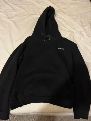 Svart hoodie från Mokovel med tryck - Svart hoodie från Mokovel med liten rosa logga fram och stort färgglatt blommotiv samt texten 'do for love' på ryggen. Klassisk känguruficka och dragsko i huvan. Perfekt för dig som gillar streetwear och unika prints.