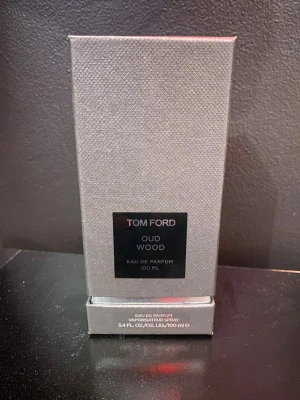 Tom Ford Oud Wood Eau de Parfum 100 ml - Säljer min Tom Ford oud wood då jag inte längre samlar på parfymer. locket är spräckt vilket syns på bild 2 och 3 men påverkar inte parfymen på något sätt, sprejar normalt och allt funkar som det ska därav priset. pris ej hugget i sten, var inte rädd att höra av dig med frågor
