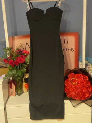 Svart långklänning med pärlband - Elegant svart långklänning med figurnära passform och axelband dekorerade med pärlor. Klänningen har en stilren, enkel design med markerad byst och raka linjer. Perfekt för dig som vill ha en klassisk och tidlös look. Aldrig använd❤️