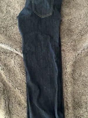 Mörkblå raka jeans från cheep monday - Säljer ett par mörkblå jeans med rak passform och klassisk bakficka. Jeansen har kontrastsömmar och är tillverkade i ett robust denimtyg som passar perfekt till en avslappnad stil. Säljer då jag inte passade i dom