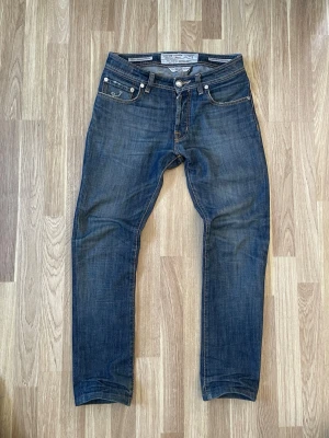 Blåa jacob choën jeans  - Ett par blåa jeans från Jacob choen med size 29. Jeansen är i bra skick men lite slitna  på vissa ställen( se bilderna). Hör av er vid minsta fråga 🙂. 