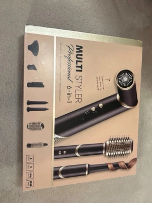 Multi Styler 6-i-1 hårstyler - Säljer en Multi Styler Professional 6-i-1 med flera utbytbara tillbehör för hårstyling. Setet innehåller olika borstar, locktillbehör och munstycken. Färgen är svart med gulddetaljer och allt kommer i originalförpackning. Perfekt för dig som vill fixa olika frisyrer hemma.