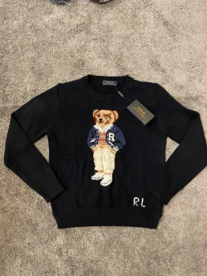 Marinblå stickad tröja Polo Ralph Lauren - Tröjan är mörkblå med vit RL text. Helt ny med taggen kvar, aldrig använd. Storlek Small. Fråga gärna om bilder och annat!   KOLLA IN MIN PROFIL FÖR KLÄDER TILL ETT BARNSLIGT PRIS 🏆 