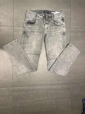 Grå Anbass jeans från Replay - Säljer ett par gråa jeans från Replay ”Anbass”. Jeansen har en mjuk denim med skön stretch. Perfekta för dig som gillar en avslappnad men ändå stilren look. Storlek waist 30 och lenght 30.